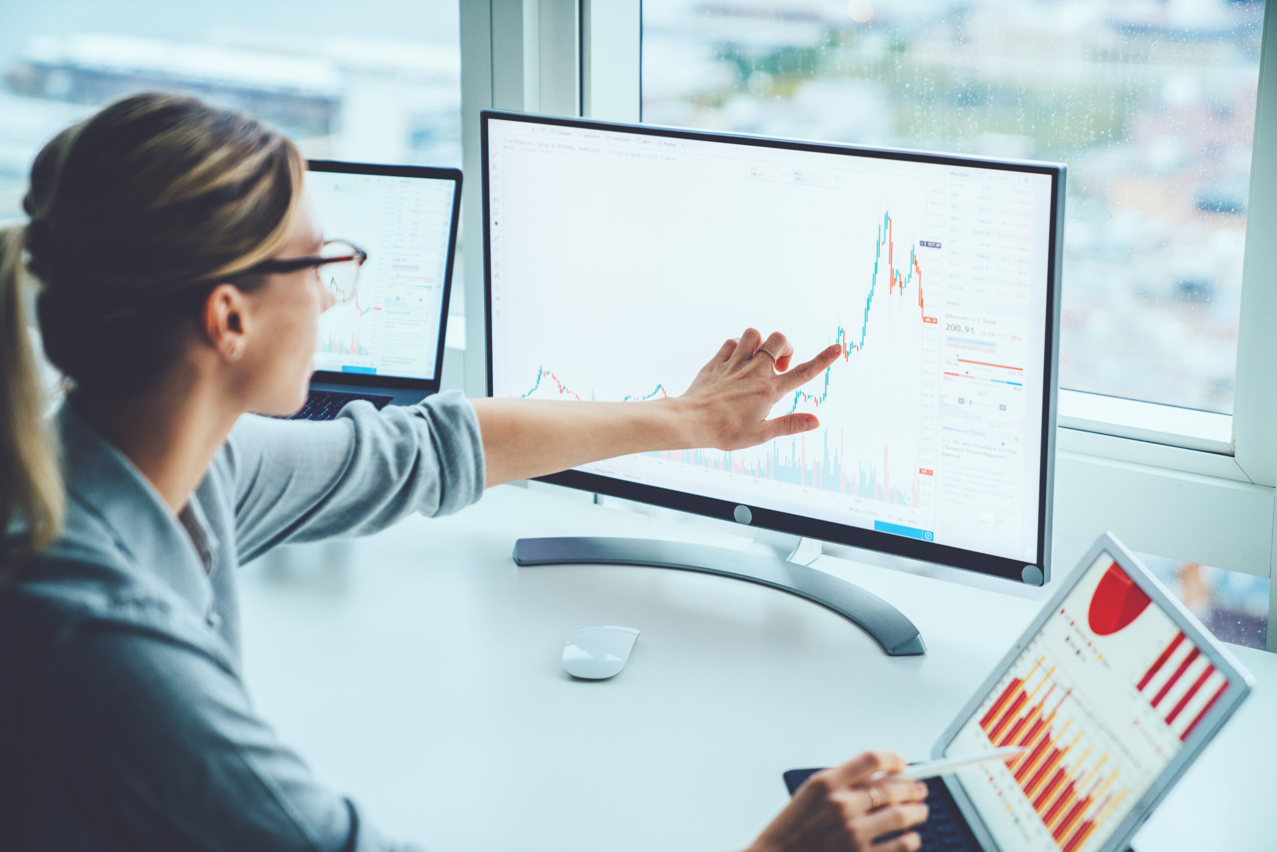 Une femme analyse un graphique financier dans un bureau moderne